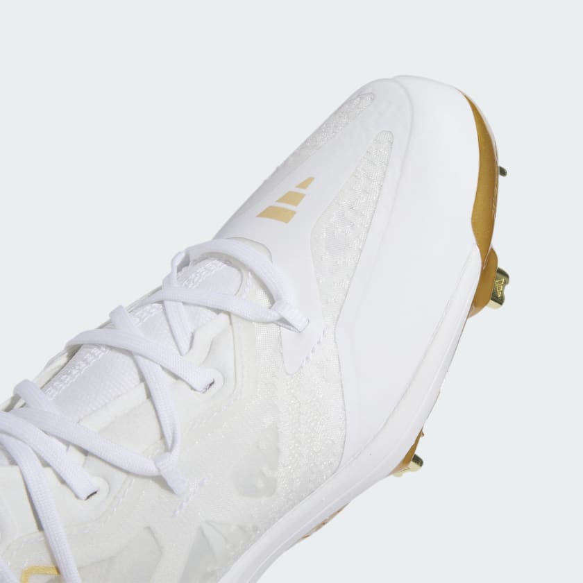 white and gold metal baseball cleats